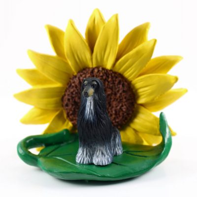 Afghan Hound Black Figurine Sitting on a Green Leaf in Front of a Yellow Sunflower