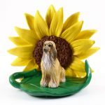 Afghan Hound Tan Figurine Sitting on a Green Leaf in Front of a Yellow Sunflower