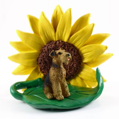 Airedale Figurine Sitting on a Green Leaf in Front of a Yellow Sunflower