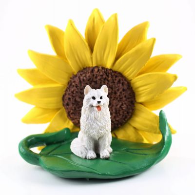 American Eskimo Figurine Sitting on a Green Leaf in Front of a Yellow Sunflower
