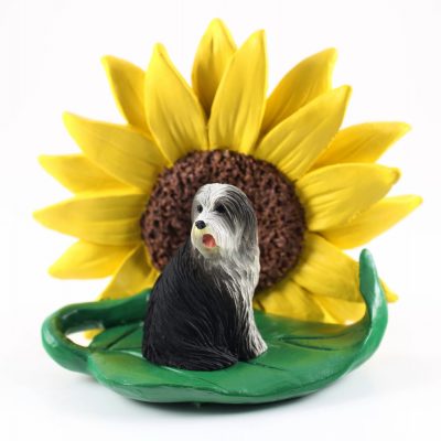 Bearded Collie Figurine Sitting on a Green Leaf in Front of a Yellow Sunflower