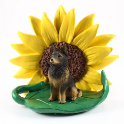 Belgian Tervuren Figurine Sitting on a Green Leaf in Front of a Yellow Sunflower