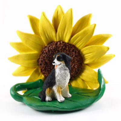 Bernese Mountain Dog Figurine Sitting on a Green Leaf in Front of a Yellow Sunflower