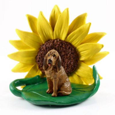 Bloodhound Figurine Sitting on a Green Leaf in Front of a Yellow Sunflower