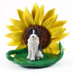 Borrder Collie Figurine Sitting on a Green Leaf in Front of a Yellow Sunflower