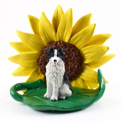 Borrder Collie Figurine Sitting on a Green Leaf in Front of a Yellow Sunflower