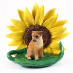 Border Terrier Figurine Sitting on a Green Leaf in Front of a Yellow Sunflower