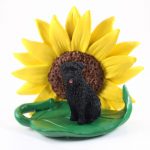 Bouvier Uncropped Figurine Sitting on a Green Leaf in Front of a Yellow Sunflower