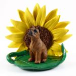 Boxer Tawny Figurine Sitting on a Green Leaf in Front of a Yellow Sunflower