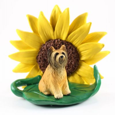 Briard Figurine Sitting on a Green Leaf in Front of a Yellow Sunflower