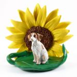 Brittany Brown/White Figurine Sitting on a Green Leaf in Front of a Yellow Sunflower