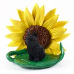Brussels Griffon Black Figurine Sitting on a Green Leaf in Front of a Yellow Sunflower