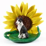 Bull Terrier Brindle Figurine Sitting on a Green Leaf in Front of a Yellow Sunflower