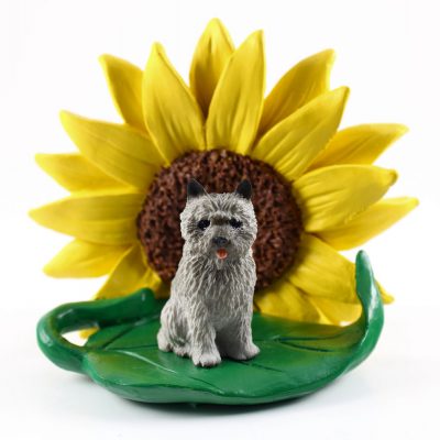 Cairn Terrier Gray Figurine Sitting on a Green Leaf in Front of a Yellow Sunflower