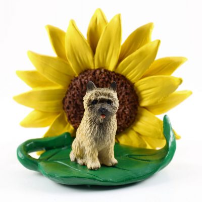 Cairn Terrier Red Figurine Sitting on a Green Leaf in Front of a Yellow Sunflower