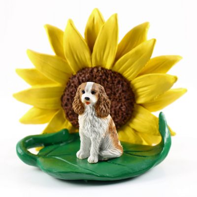Cavalier King Charles Brown/White Figurine Sitting on a Green Leaf in Front of a Yellow Sunflower