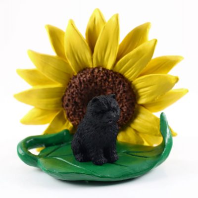 Chow Chow Black Figurine Sitting on a Green Leaf in Front of a Yellow Sunflower