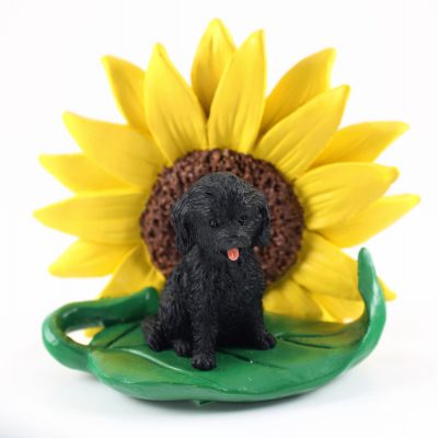 Cockapoo Black Figurine Sitting on a Green Leaf in Front of a Yellow Sunflower
