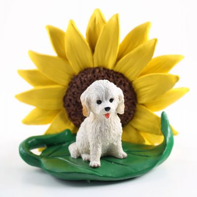 Cockapoo White Figurine Sitting on a Green Leaf in Front of a Yellow Sunflower