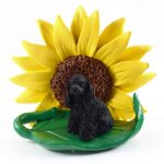 Cocker Spaniel Black Figurine Sitting on a Green Leaf in Front of a Yellow Sunflower