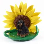 Cocker Spaniel Black/Brown Figurine Sitting on a Green Leaf in Front of a Yellow Sunflower