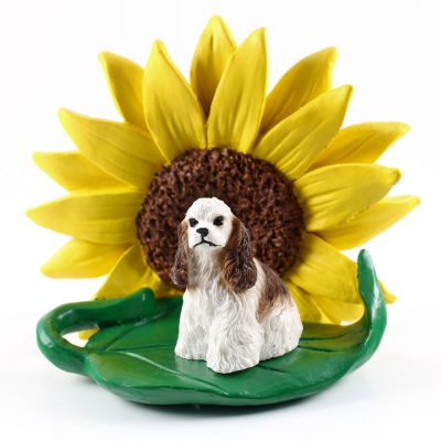 Cocker Spaniel Brown/White Figurine Sitting on a Green Leaf in Front of a Yellow Sunflower