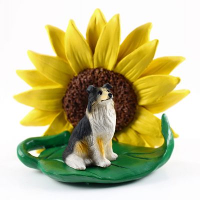 Collie Tri Color Figurine Sitting on a Green Leaf in Front of a Yellow Sunflower