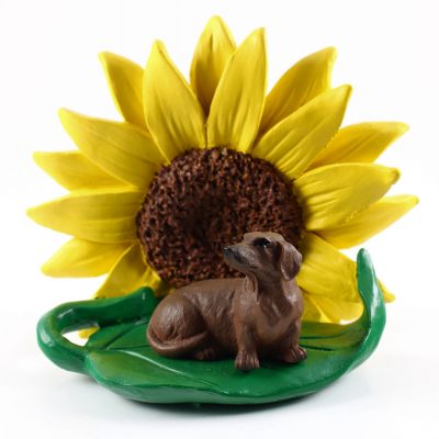 Dachshund Red Figurine Sitting on a Green Leaf in Front of a Yellow Sunflower