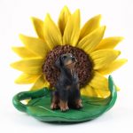 Doberman Pinscher Black Uncropped Figurine Sitting on a Green Leaf in Front of a Yellow Sunflower