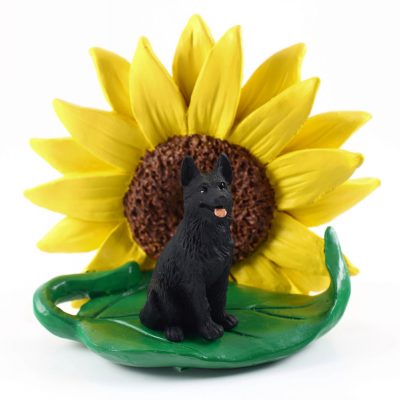 German Shepherd Black Figurine Sitting on a Green Leaf in Front of a Yellow Sunflower