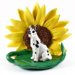 Great Dane Harlequin Figurine Sitting on a Green Leaf in Front of a Yellow Sunflower