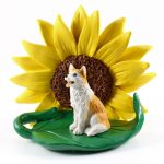 Husky Red/White Blue Eyes Figurine Sitting on a Green Leaf in Front of a Yellow Sunflower
