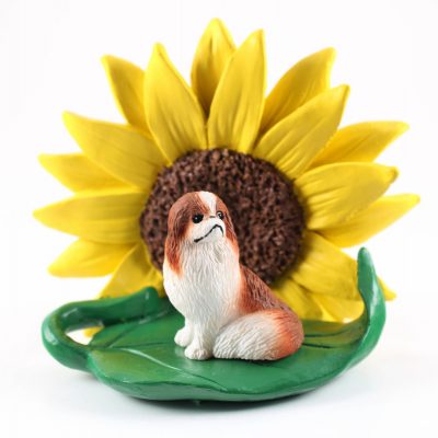 Japanese Chin Red Figurine Sitting on a Green Leaf in Front of a Yellow Sunflower