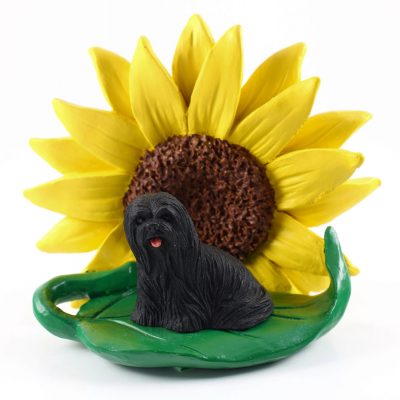 Llhasa Apso Black Figurine Sitting on a Green Leaf in Front of a Yellow Sunflower
