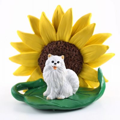 Mini American Eskimo Figurine Sitting on a Green Leaf in Front of a Yellow Sunflower