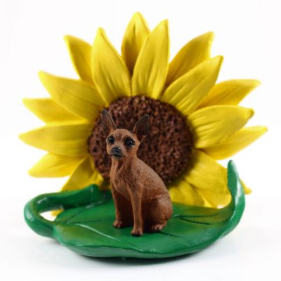 Mini Pinscher Red Figurine Sitting on a Green Leaf in Front of a Yellow Sunflower