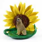 Norwegian Elkhound Figurine Sitting on a Green Leaf in Front of a Yellow Sunflower