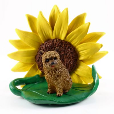 Norwich Terrier Figurine Sitting on a Green Leaf in Front of a Yellow Sunflower