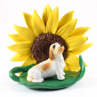 Petit Basset Griffon Vendeen Figurine Sitting on a Green Leaf in Front of a Yellow Sunflower