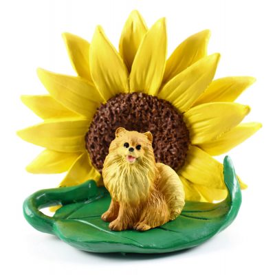 Pomeranian Red Figurine Sitting on a Green Leaf in Front of a Yellow Sunflower