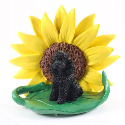Poodle Black Sport Cut Figurine Sitting on a Green Leaf in Front of a Yellow Sunflower