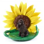 Poodle Chocolate Figurine Sitting on a Green Leaf in Front of a Yellow Sunflower
