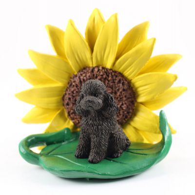 Poodle Chocolate Sport Cut Figurine Sitting on a Green Leaf in Front of a Yellow Sunflower