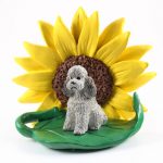 Poodle Gray Sport Cut Figurine Sitting on a Green Leaf in Front of a Yellow Sunflower