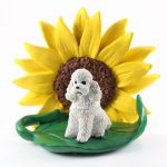 Poodle White Sport Cut Figurine Sitting on a Green Leaf in Front of a Yellow Sunflower