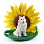 Samoyed Figurine Sitting on a Green Leaf in Front of a Yellow Sunflower