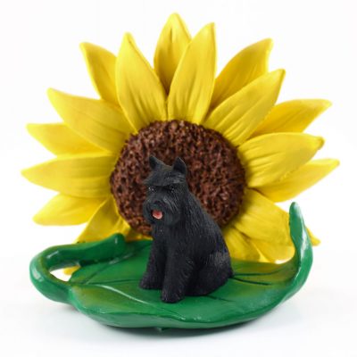 Schnauzer Black Figurine Sitting on a Green Leaf in Front of a Yellow Sunflower