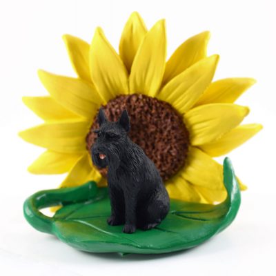 Schnauzer Black Giant Figurine Sitting on a Green Leaf in Front of a Yellow Sunflower