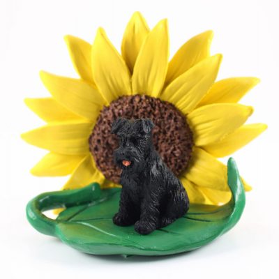 Schnauzer Black Uncropped Figurine Sitting on a Green Leaf in Front of a Yellow Sunflower