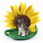 Schnauzer Gray Uncropped Figurine Sitting on a Green Leaf in Front of a Yellow Sunflower
